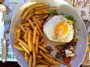 Hamburger is hiding under the egg! It is on a bun with all the trimmings. Only the egg was unexpected. 