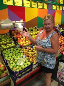 Rita demonstrating her compliance with local rules regarding the wearing of plastic gloves when squeezing the melons and handling other fruits and vegetables.  All the fashionable women are wearing plastic gloves this season in Italy.  