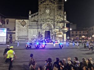 The first of the procession is arriving right behind this police motorcycle escort!